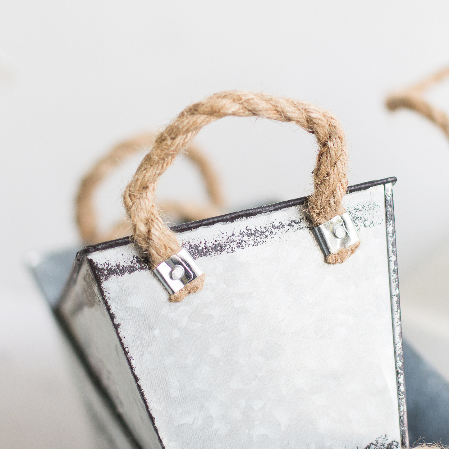 Dekorativ blomster- och trädgårdsbehållare i metall med hampasnörehandtag