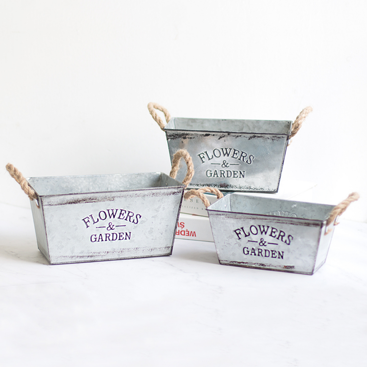 Dekorativ blomster- och trädgårdsbehållare i metall med hampasnörehandtag